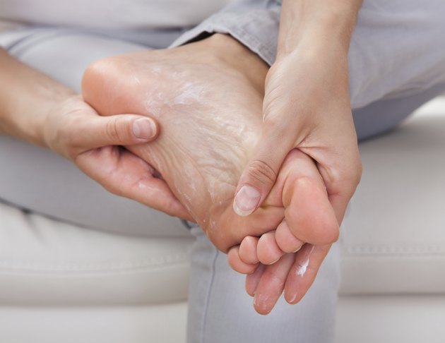Woman applying cream on feet