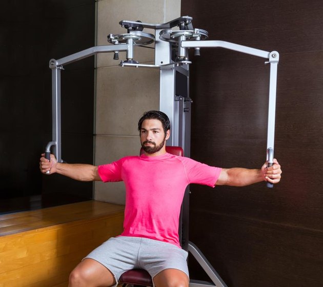 pec-deck fly flies pec deck chest workout man exercise at gym