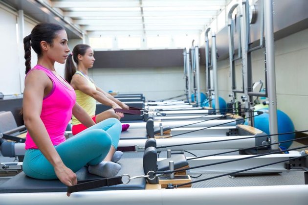 Pilates reformer workout exercises women at gym indoor