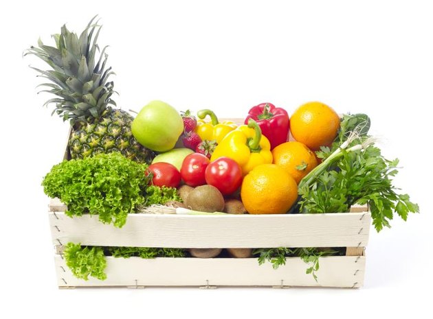 Fruits and vegetables in a wooden crate isolated on white