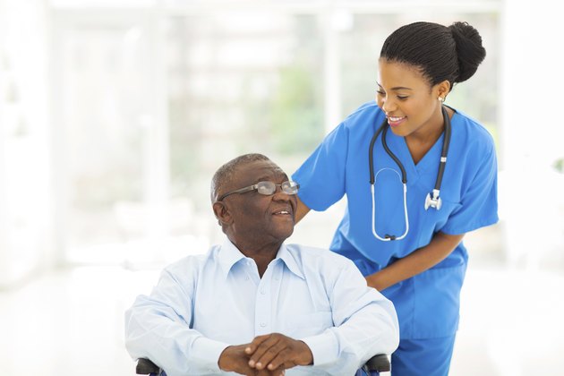 african nurse taking care of senior patient in wheelchair