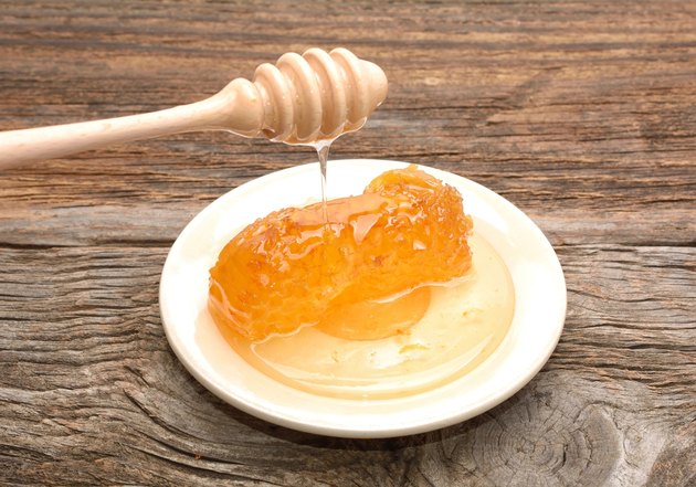Honey with honeycomb on wooden table