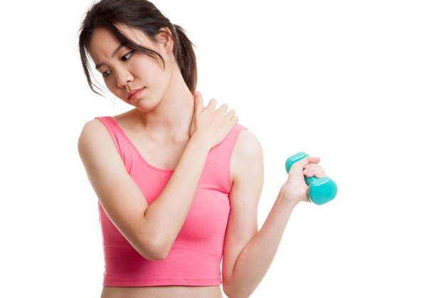 Asian healthy girl got shoulder pain with dumbbell isolated on white background.
