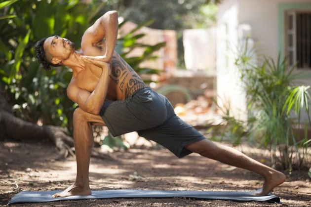 Young man does yoga in nature.