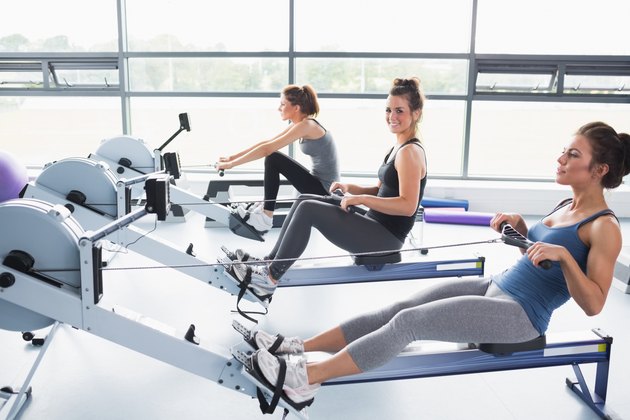 Three women exercising on rowing machines