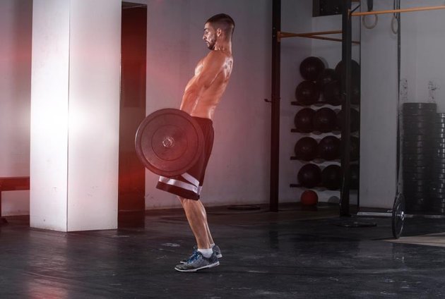 Handsome and muscular young man practice exercises in crosfit club with great weight