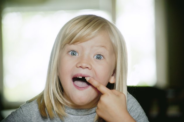 Portrait of girl (6-7) showing her missing tooth