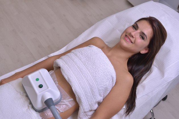 Beautiful young woman getting cryolipolyse treatment in cosmetic