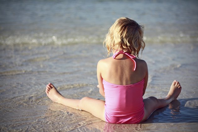 child sitting on the beach