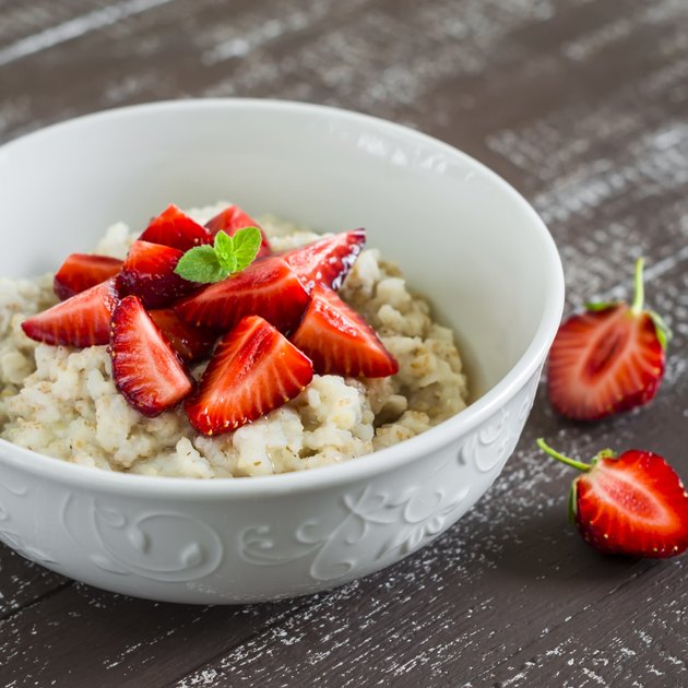 Oatmeal with honey and strawberries in a white bowl