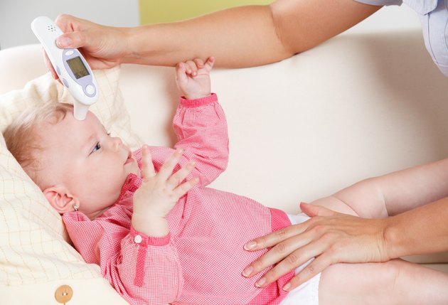 Baby with a digital thermometer