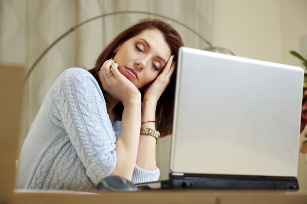 Tired woman with closing eyes sitting on her workout