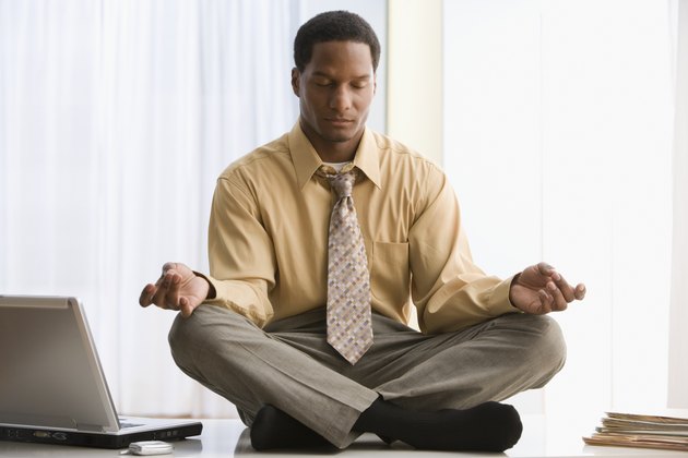 African American businessman meditating on desk