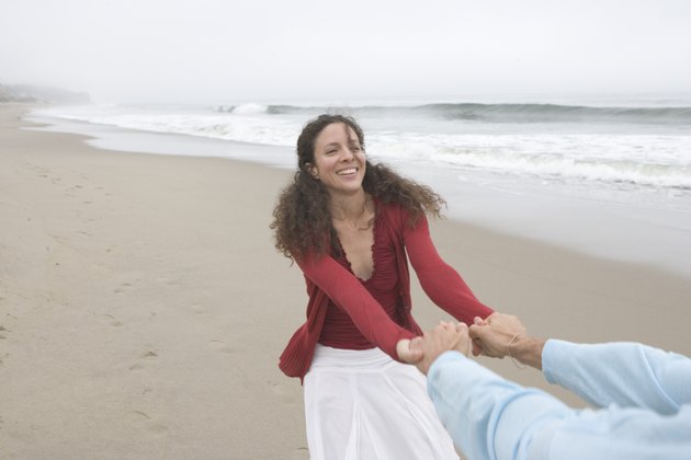 Woman pulling her boyfriend at the beach