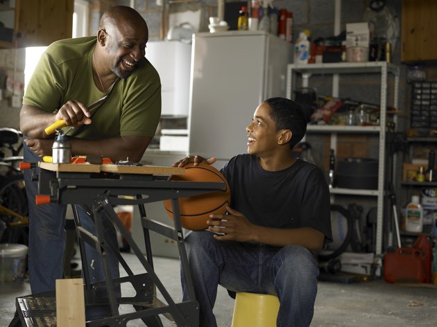 Father and Son talking over workbench in garage