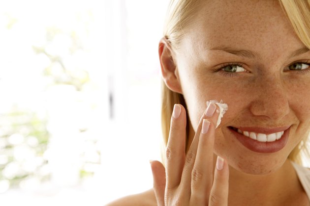 Woman applying skin cream