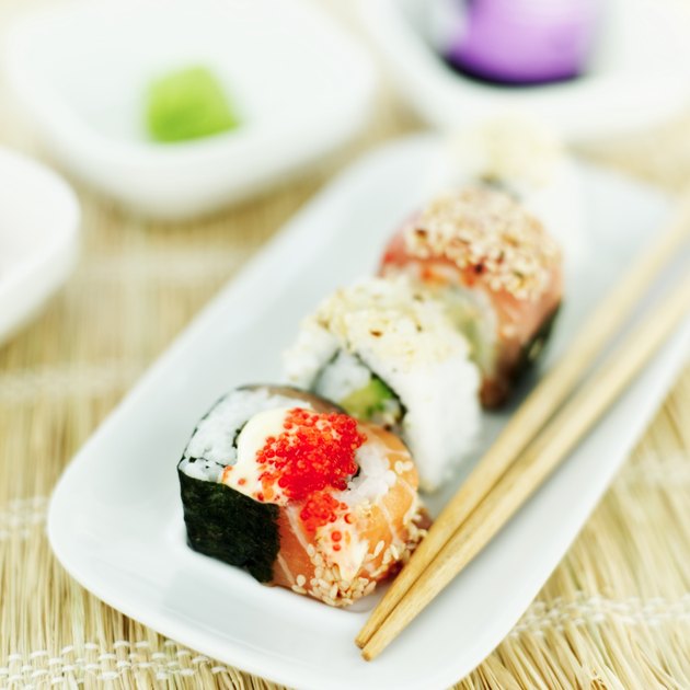 close-up of a tray of assorted sushi rolls served with chopsticks