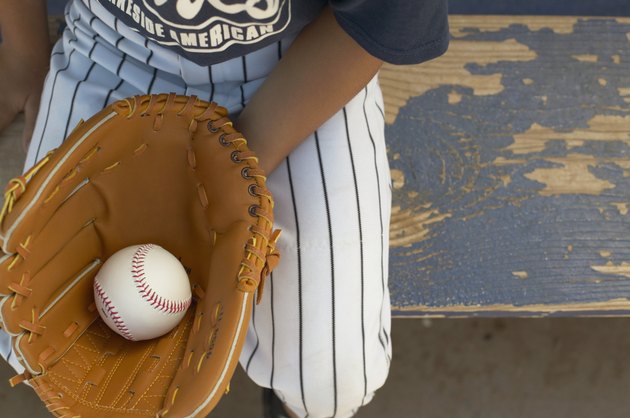 High angle view of a young boy wearing a baseball mitt holding a ball