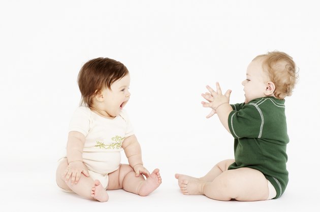Female baby (6-9 months) laughing, baby boy clapping hands