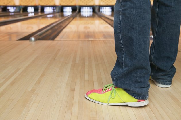 Low section view of a young person standing in a bowling alley