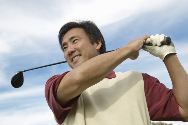 Smiling Man Swinging a Golf Club
