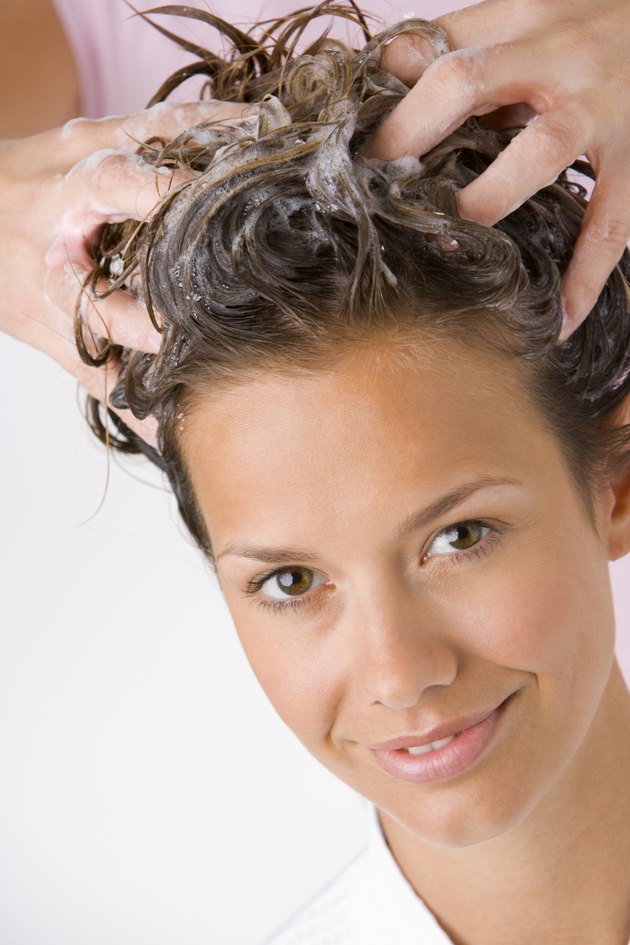 Hands washing woman's hair