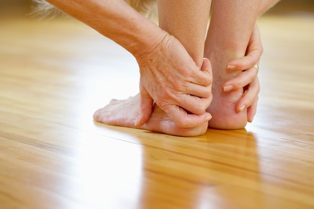 Hands and feet of woman in standing forward bend yoga pose