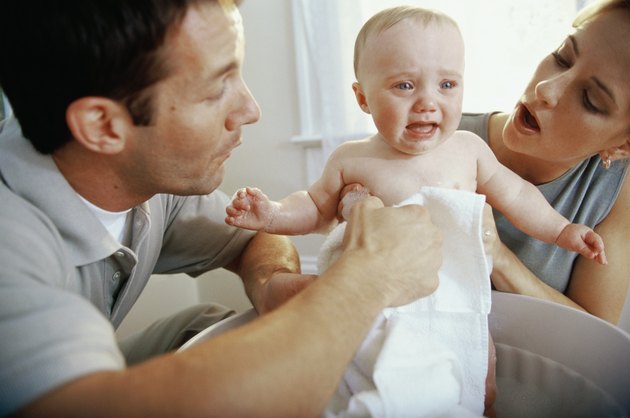 Close-up of parents giving their son a bath