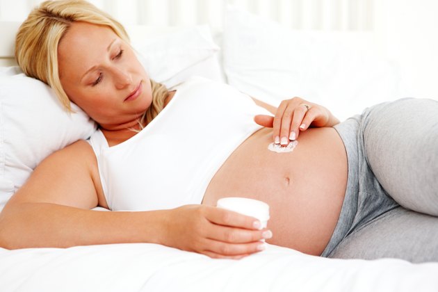 Pregnant Woman Applying Cream to Her Stomach