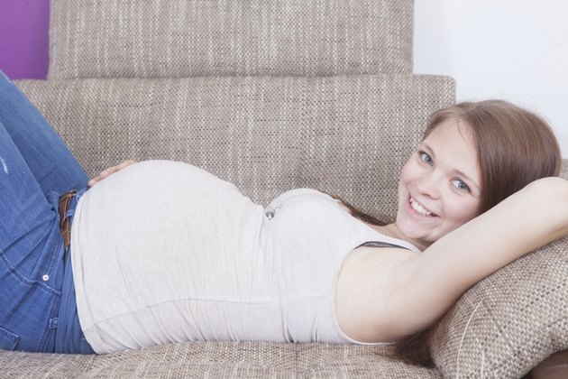 Pregnant Girl is laying on a sofa