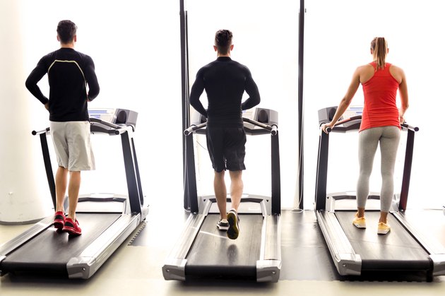 Group of young people using treadmills in a gym