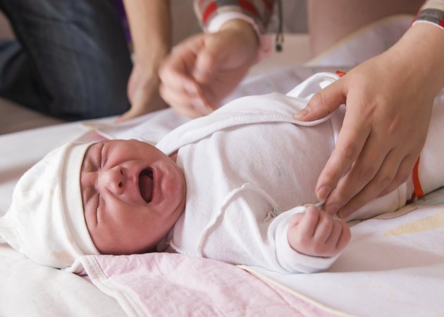 Newborn baby crying on the bed