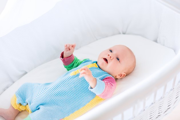Cute baby boy in a white crib