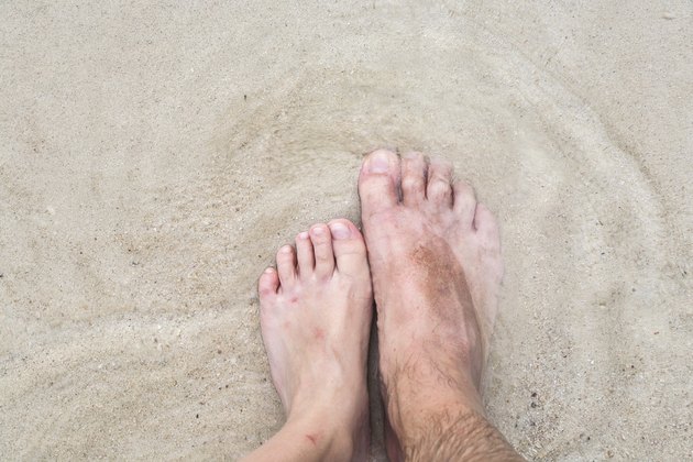 feet of father and son at the beach