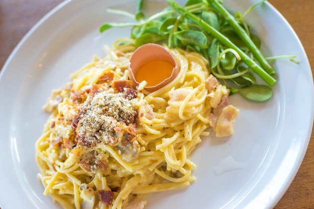 spaghetti carbonara on bowl with egg .closeup