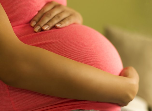 Pregnant woman embracing her belly