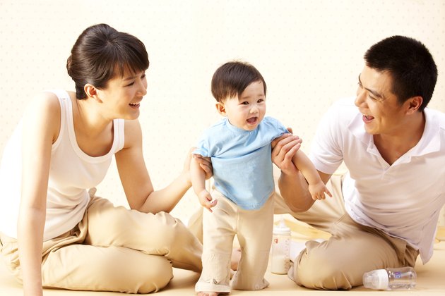 Mother and father teaching baby to walk