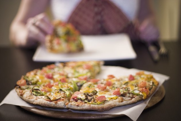 "Woman eating pizza, front view"