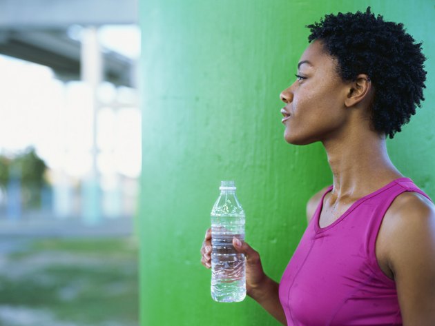 Side profile of a young woman holding a bottle of water