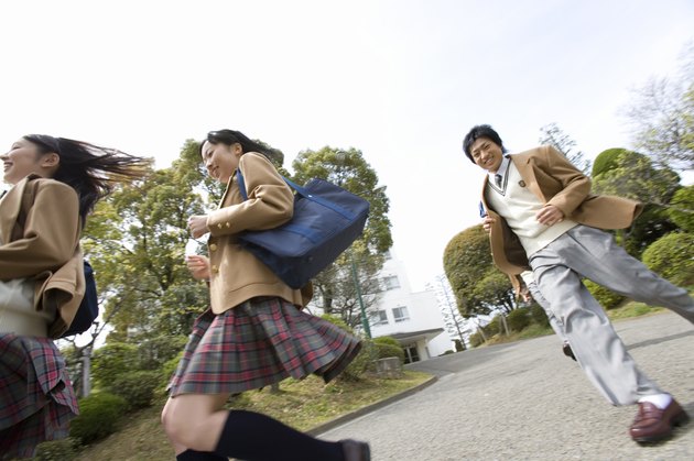 Three high school students running, low angle view, Japan
