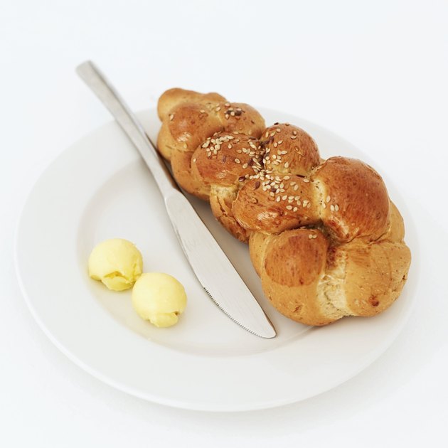 bread on a plate with butter and a knife