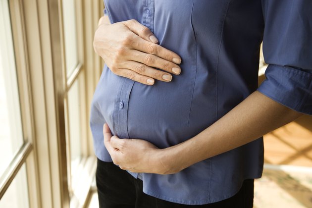 Pregnant woman supporting belly
