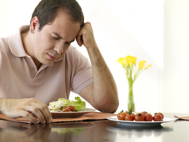 Sad man eating a salad