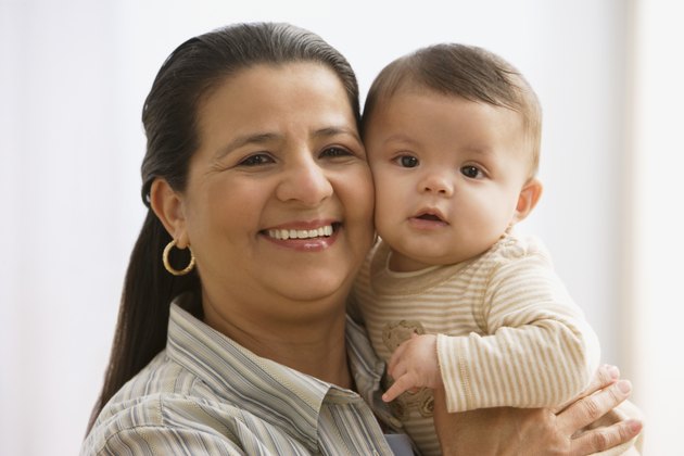 Hispanic mother hugging baby