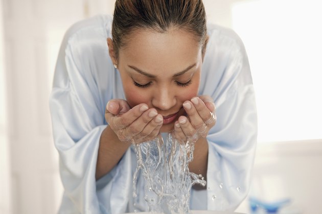 Woman splashing water on face