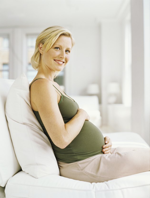side profile of a pregnant woman smiling and looking up