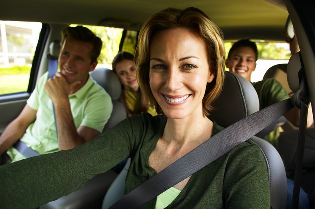 Portrait of a couple in a car with their teenage son and daughter (17-20)