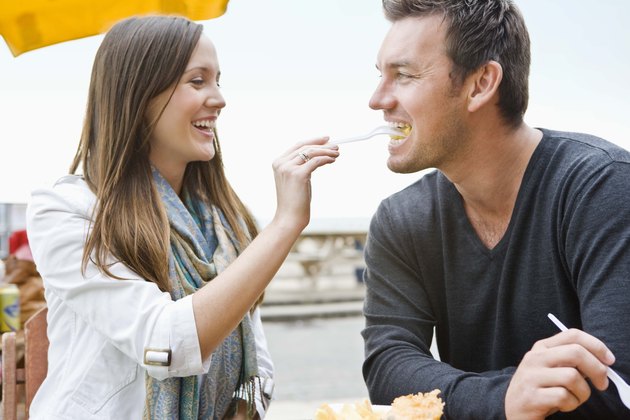Couple eating fish and chips outdoors