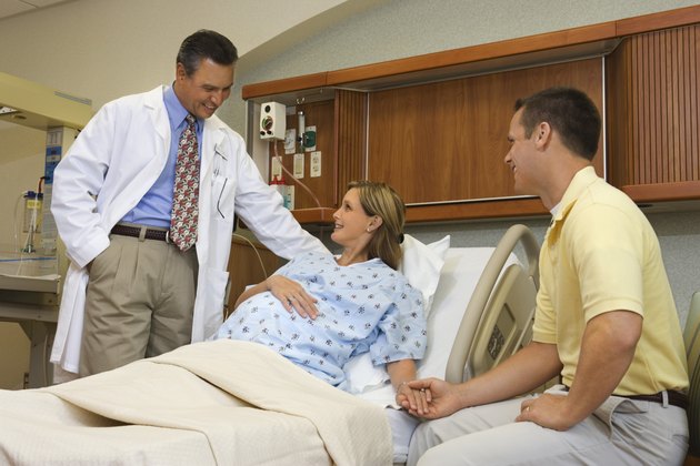 Husband and pregnant wife in hospital with doctor
