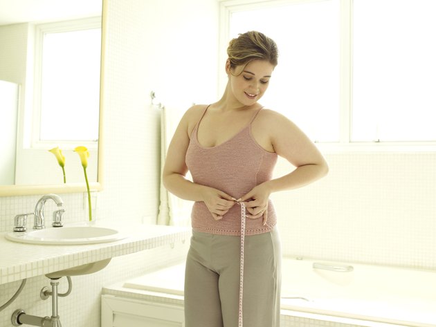Woman measuring her waist